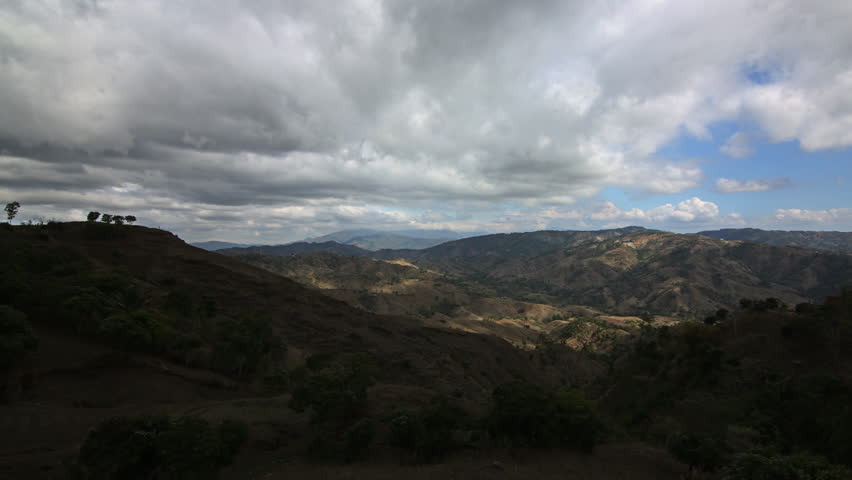 Time lapse of clouds passing overhead with view looking toward dry mountains in Haiti.