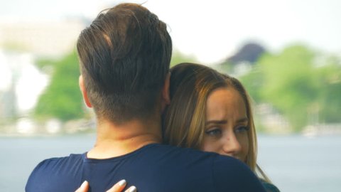 Saying goodbye - a man comforting a sad woman