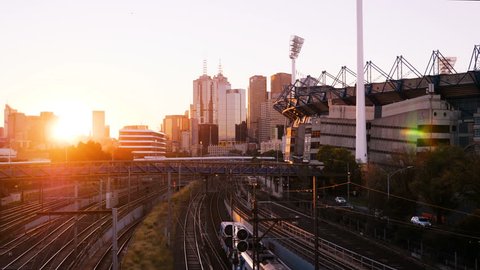 Melbourne, Victoria, Australia - May 26, 2018: Static shot of sunset in Brunton Avenue. Melbourne cricket ground, passing trains and Melbourne downtown skyline in the background. 