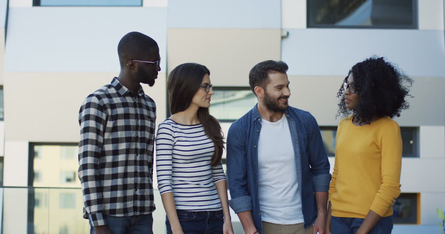 Portrait shot of the succesful team of young mixed races people standing in front of the camera all together and smiling. Outdoor
