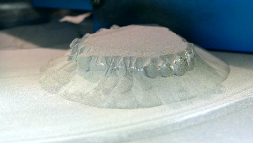 Man is cleaning wit brush object printed on 3d metal printer from metal powder close-up. Dental crowns created in laser sintering machine. DMLS, SLM, SLS additive technology. 4.0 industrial revolution