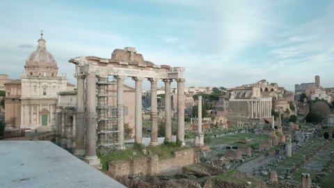 Camera tracking left elevated wide overview of Roman Forum or Foro Romano ruins seen from Capitoline Hill viewpoint balcony in Rome, Italy. 4K UHD at 29.97fps