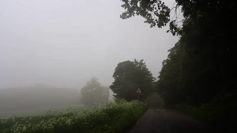 A country lane at the top of a misty bank