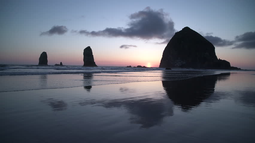 Haystack Rock, Cannon Beach Sunset 4K. UHD. Sunset at Haystack Rock in Cannon Beach, Oregon as the surf washes up onto the beach. United States. 4K, UHD.
 Royalty-Free Stock Footage #1011555833