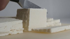 Slow motion cutting of cow milk cheese with knife