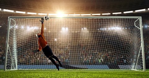Soccer goalie fails to catch a ball on a prefessional soccer stadium. Athlete wears unbranded sport clothes