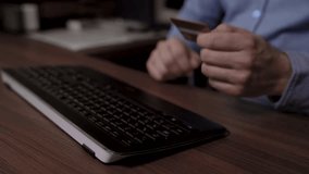 Close up of a businessman hands. He enters text on the keyboard and then uses his credit card to pay online. Motorized slider footage video.