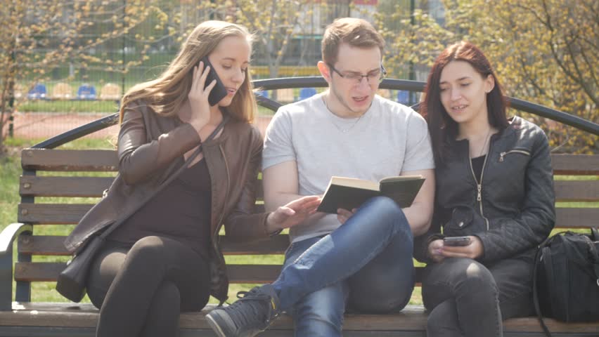 friends rest in a park sitting on a bench