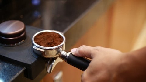 Making Ground Coffee with Tamping fresh coffee. Close-Up. Making coffee from start to finish.Tamping Fresh Ground Coffee. Professional barista.