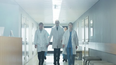Team of Doctors, Nurses and Assistants Walking through the Hallway of the Hospital. Professional Medical Personnel Working, Saving Lives. Slow Motion. Shot on RED EPIC-W 8K Helium Cinema Camera.
