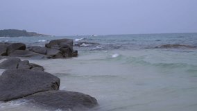 View of seascape beautiful breaking waves on beach and wave crashing on rocks. Holiday by sea concept, Slow motion shot