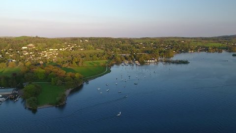 Aerial footage over Lake Windermere in National District of England UK. Beautiful British landscapes in English mountains view at sunset. 
