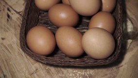 Basket with eggs on a round wooden table, rotation 360 degrees. Beautiful dark background.