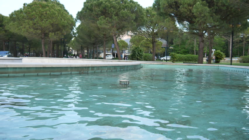 Water drops splashing on water surface in slow motion. Close up of water fountain. Water jet splashing
