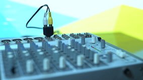 The Music Audio Mixer stands on the Desk and Adjusts the Sound Level. Mechanical Equalizer for Voice-Over DJing of Concerts and Events. Close-up of the inputs, outputs, controllers and switches.