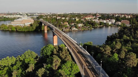 Aerial footage of the Stockholm island Stora Essingen and two tramway trains meeting on the bridge "Alviksbron", a part of "Tvärbanan"