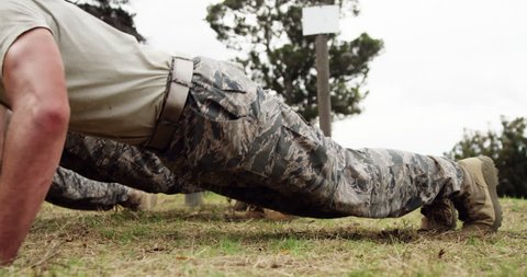 Military soldiers dosing push-ups during obstacle course at boot camp 4k