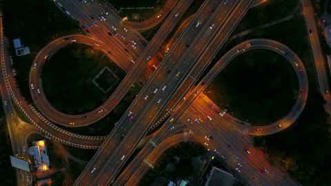 4K. Aerial view of infinity highway road interchange with busy urban traffic speeding on the road at night. Junction network of transportation in Bangkok, Thailand. taken by drone