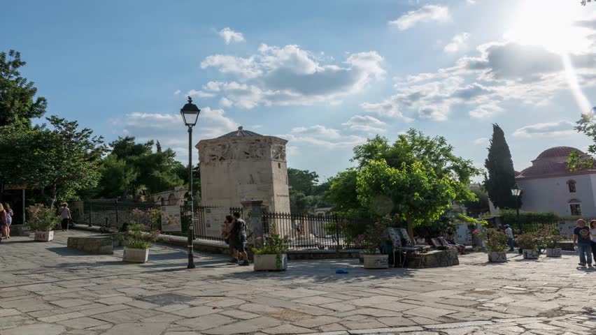 tourists walking around tower of the winds, athens, greece