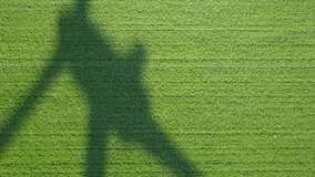 Raw drone video of a wind turbine shadow on a wheat field