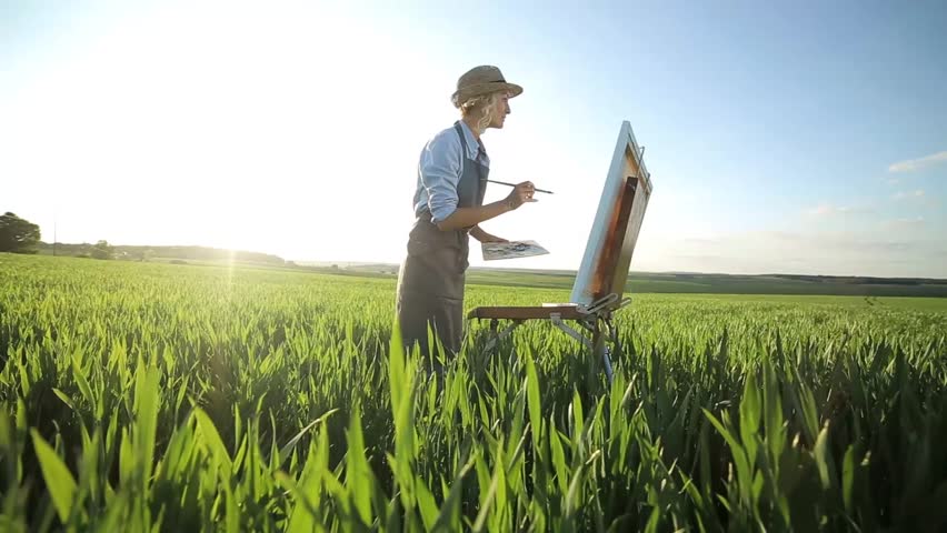 Young artist painting an floral landscape, summer time