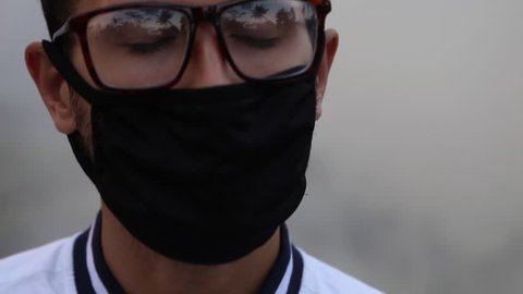 Man covered his face with anti-pollution mask closing eyes