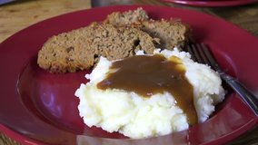 Spooning brown gravy onto mashed potatoes - Powered by Shutterstock - Get 15% off with code: PIKWIZARD15