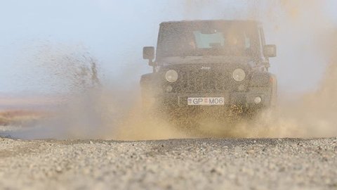 VIK, ICELAND - MAY 03, 2018. Jeep Wrangler Unlimited four wheel drive vehicledriving through puddle with big splash on gravel road