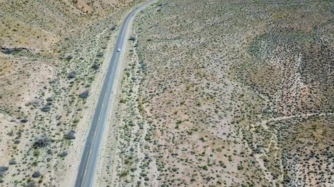 Desert mountain highway with white car outside Las Vegas Nevada USA