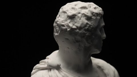 Ancient roman era white marble statue of Brutus rotating and showing every angles. Closeup shot with black background.