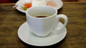 Video of person drinking black coffee in cafe