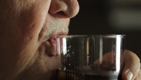 Mature man drinking what could be soda or a cocktail