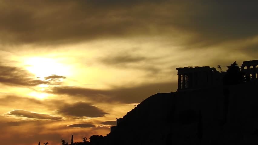 Still video from iconic Acropolis hill and the Parthenon as seen from rooftop at sunset with golden colours and beautiful cloud formations, Athens historic center, Attica, Greece