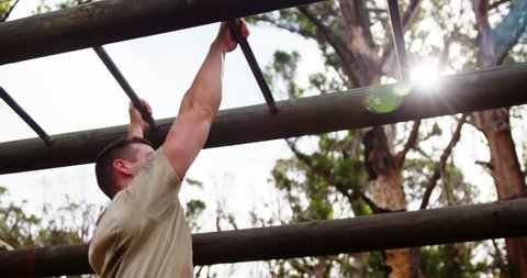 Military soldier climbing monkey bars at boot camp 4k