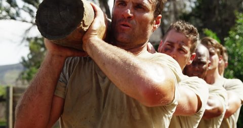 Military troops carrying heavy wooden log during obstacle course at boot camp 4k