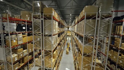 Boxes stored on high shelves at industrial warehouse. Finished goods in trading warehouse on production plant drone view