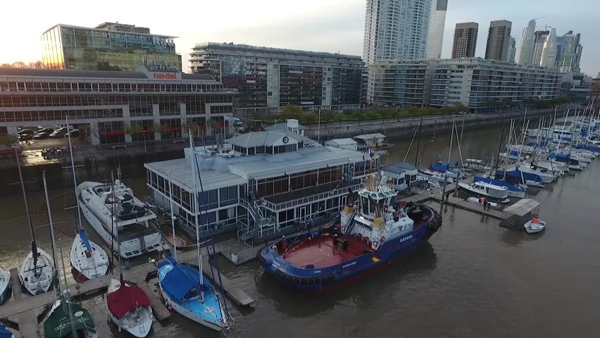 Aerial scene with drones. Camera traveling back watching boat and city. Puerto Madero, Buenos Aires - Argentina.