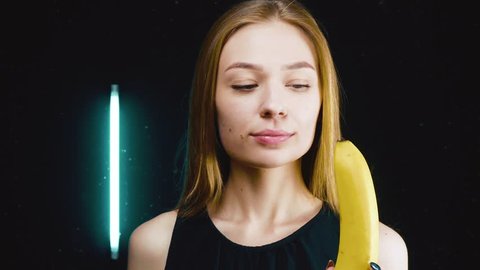 The girl is biting a banana.
