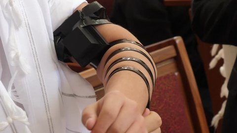 The laying of Tefillin Jewish man put on the hand a tefillin
