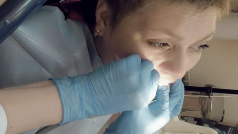 Woman at the dentist clinic office gets dental medical examination and treatment. Vertical format video.