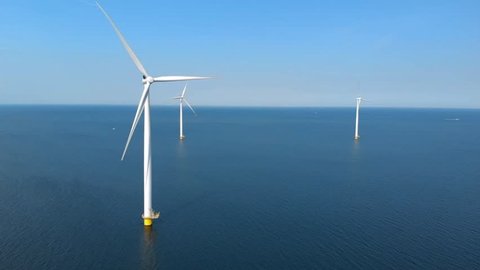 Slow motion drone view from the sky at Windmill park in the lake IJsselmeer in Flevoland Netherlands , windmill farm offshore in the sea