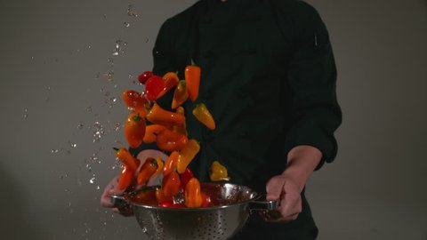 Chef with colander full of peppers splashing in super slow motion, shot with Phantom Flex 4K