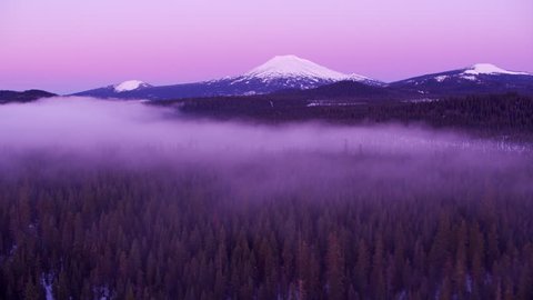 Oregon circa-2018. Flying towards Mt. Bachelor at dawn with low fog over forest. Shot from helicopter with Cineflex gimbal and RED Epic-W camera. స్టాక్ వీడియో