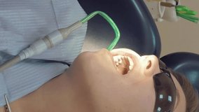 Woman at the dentist clinic office gets dental medical examination and treatment. Vertical format video.
