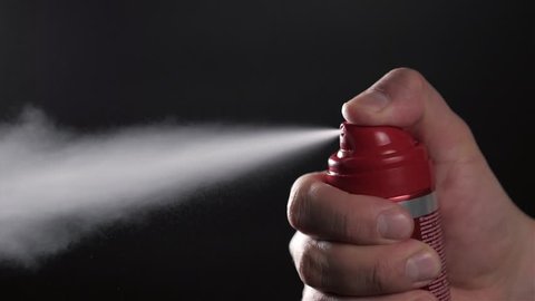 Close-up view of human hand and spray bottle isolated on black parfume moscito spray insects