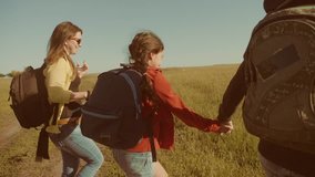 happy family slow motion video walking on nature boy girl and mom in a field on trekking trip. tourists with lifestyle backpacks traveling. happy family travel tourism concept