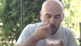 man with beard eat dessert with strawberry .