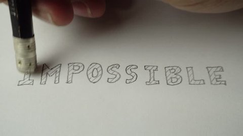 Changing the word impossible to possible. Impossible word gets the ''im'' removed to make it possible. Pencil erase it to possible. Closeup 4K Resolution.