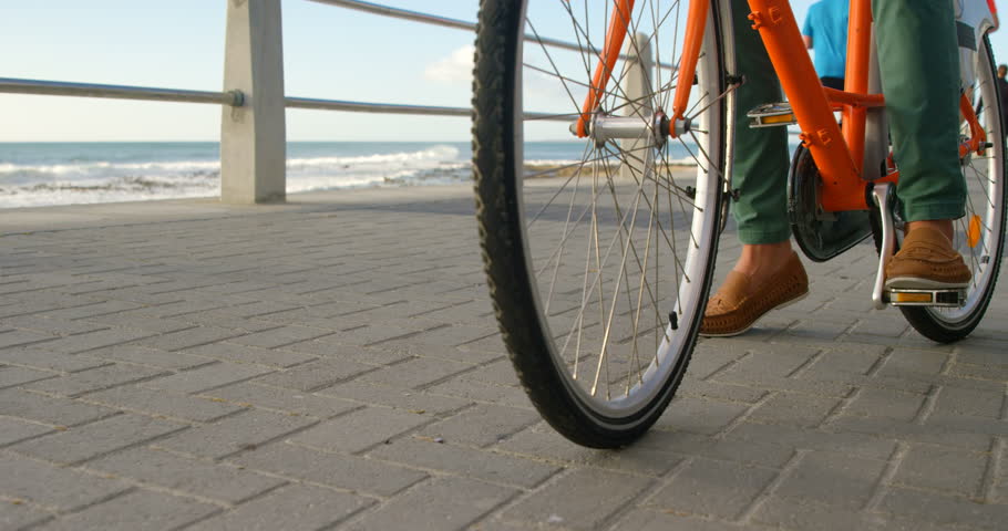 Low section of man cycling on the beach 4k