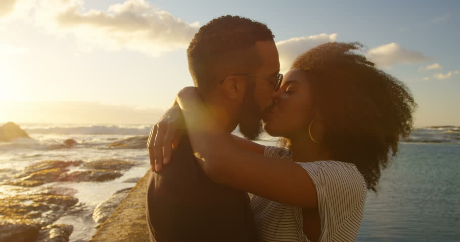 Couple kissing each other on the beach at dusk 4k